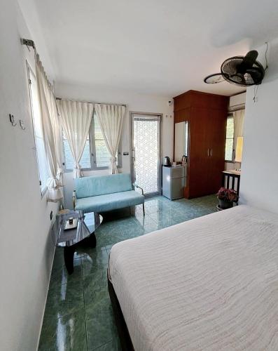a bedroom with a bed and a blue couch at Firefly Bungalows Samui in Ban Bang Po