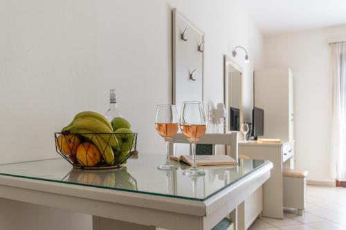 a table with two glasses of wine and a bowl of fruit at Plaka Hotel II in Plaka