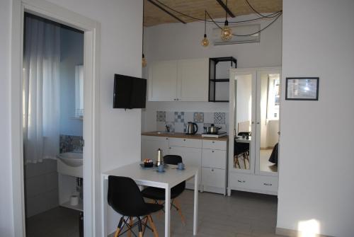 a kitchen with white cabinets and a table and chairs at Al Faro Bianco B&B e Residence con parcheggio in Vasto