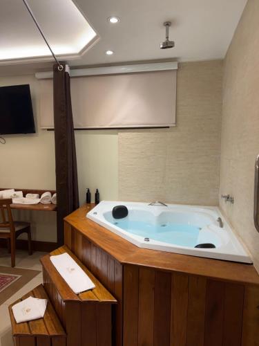 a large bath tub in a room with a table at Pousada Princesa Isabel - Visconde in Petrópolis