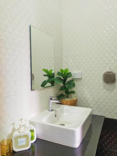 a bathroom with a white sink and a mirror at Aonang Homie Pool villa in Ao Nang 