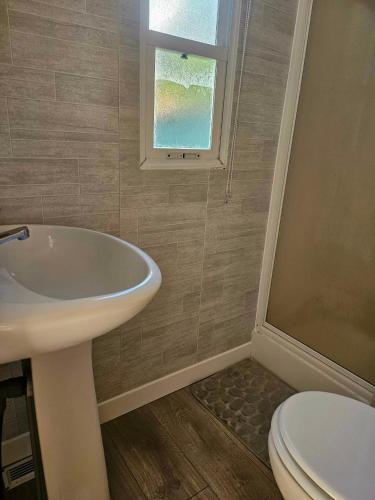 a bathroom with a sink and a toilet and a window at mobil-home in Souméras
