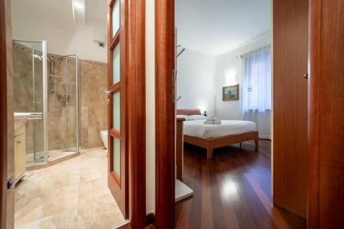 a bathroom with a shower and a bedroom with a bed at Dimore Verona in Verona