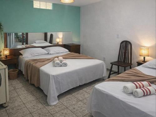 a hotel room with two beds with towels on them at Hostal B&C in Angra dos Reis