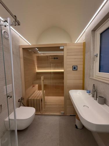 a bathroom with a shower and a toilet and a sink at Bellavitarooms-Fiore di Maggio Luxury Suites in Matera