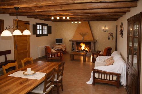 a living room with a table and a fireplace at Casa con piscina y vistas a montaña - Cal Solsona in La Baronia de Rialb