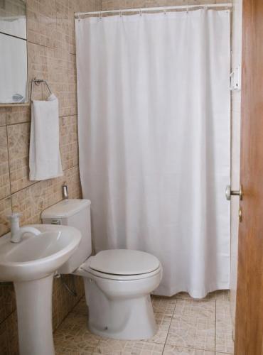 a bathroom with a white toilet and a sink at Hostal B&C in Angra dos Reis