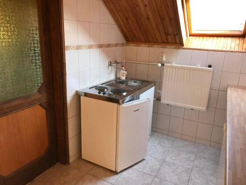 a small kitchen with a sink and a stove at PBJ Apartman in Pilisborosjenő