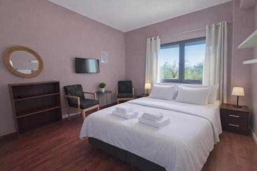 a bedroom with a large white bed with a window at SUNNY 3, Two-bedroom apartment with parking in Komotini