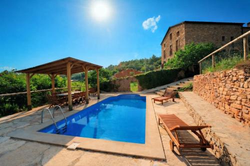 a swimming pool with a wooden gazebo at Casa con piscina y vistas a montaña - Cal Solsona in La Baronia de Rialb