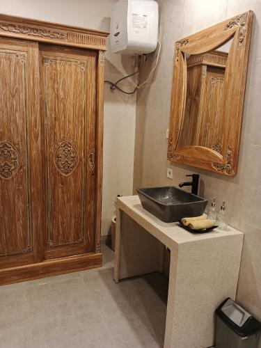a bathroom with a sink and a wooden cabinet at Umakami Pertiwi Villas in Ubud