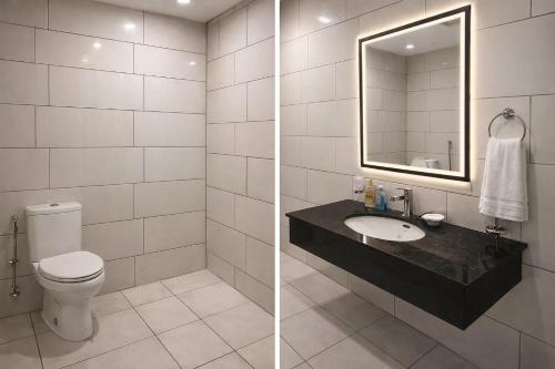 a bathroom with a toilet and a sink and a mirror at Prime Stays Rezidor in Rawalpindi