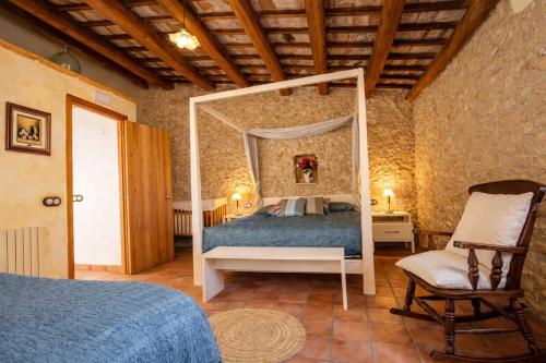 a bedroom with a canopy bed and a chair at Catalunya Casas Captivating Villa in the Vineyard close to Sitges in Bisbal del Penedès
