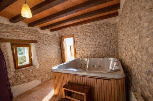 a bathroom with a large tub in a stone room at Catalunya Casas Captivating Villa in the Vineyard close to Sitges in Bisbal del Penedès