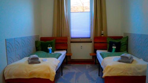two twin beds in a room with a window at Ferienwohnung Hanna in Bitterfeld