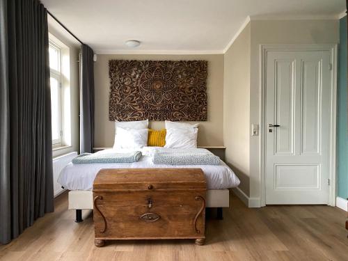a bedroom with a large bed with a wooden trunk at B&B Bakenberg in Arnhem