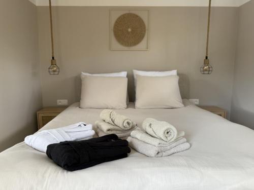 a white bed with towels on top of it at Wellness huisje Sonne Oase in Lanaken