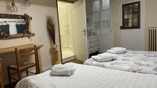 una camera da letto con due letti, uno specchio e una cassettiera di Maison de Rêve a Notre-Dame-du-Touchet