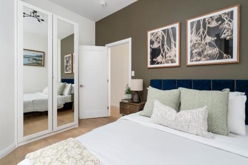 a bedroom with a white bed and a mirror at Spacious 2BR near UofT and College in Toronto
