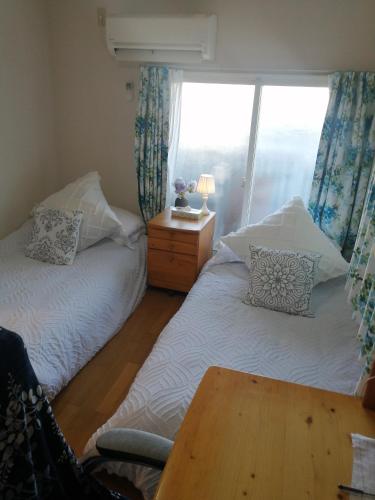 two beds in a room with a table and a window at Tokyo downtown牡丹莊 in Tokyo