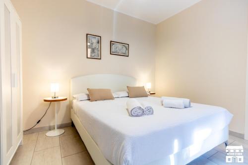 a bedroom with a large white bed with two pillows at LA VISTA by Design Studio in Bellano