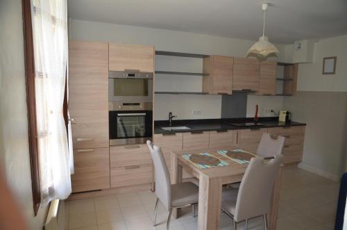 a kitchen with a wooden table and white chairs at Villa Les Myrtilles in Thonon-les-Bains