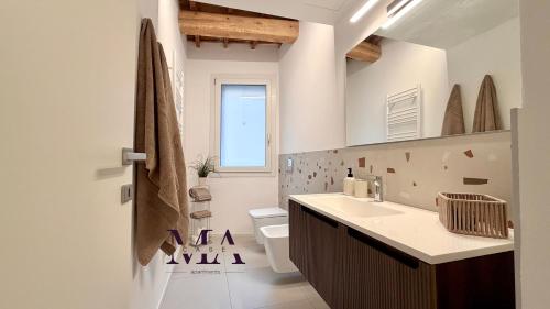 a bathroom with a sink and a toilet and a window at MAcase Apartments in Ferrara