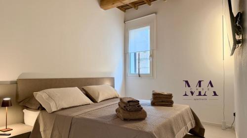 a bedroom with a bed with two towels on it at MAcase Apartments in Ferrara
