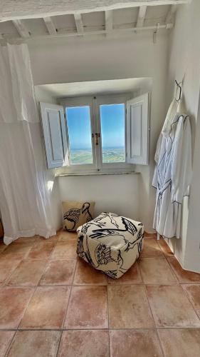a room with a window and a pillow on the floor at SuSuMare in Campiglia Marittima