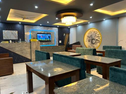 a restaurant with tables and chairs and a tv at Hotel vasurai and restaurant in Nākuri