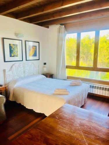 a bedroom with two beds and a large window at Apartamentos Monterodiles in Liñero