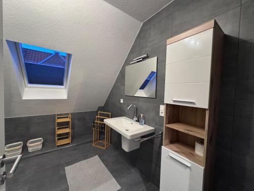 a bathroom with a sink and a window at Ferienwohnung Schöne Aussicht in Hinte