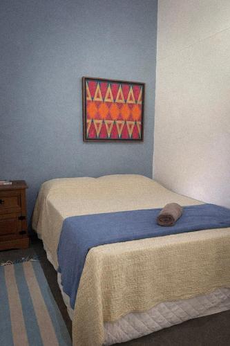 a bedroom with two beds and a painting on the wall at Suite 3 in São Domingos