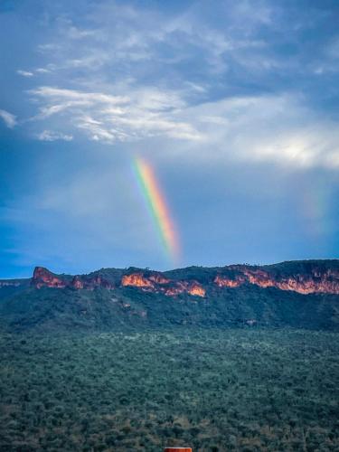a rainbow in the sky over a mountain range at Suite 3 in São Domingos