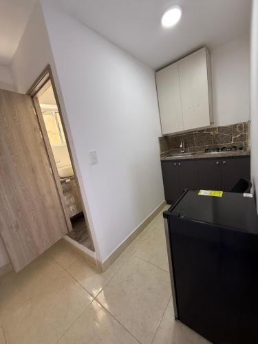 a kitchen with a black counter and a sink at Apartaestudio grupal privado dentro de hotel in Medellín