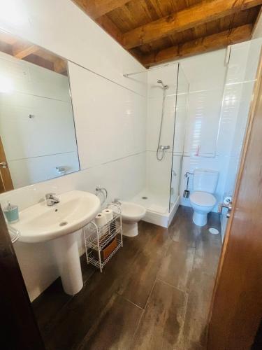 a white bathroom with a sink and a toilet at Apartamentos Monterodiles in Liñero
