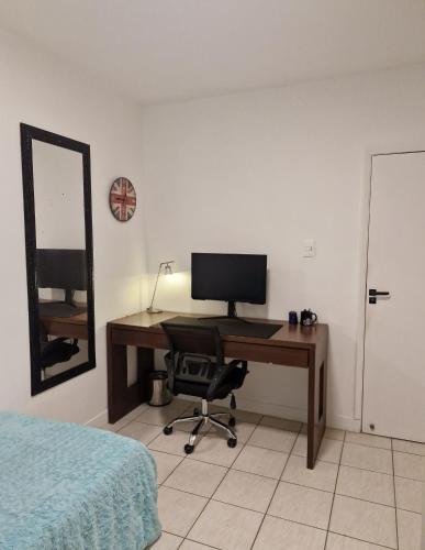 a bedroom with a desk with a computer on it at Pacífico Guest House Recife - Polo Médico e Universidades in Recife