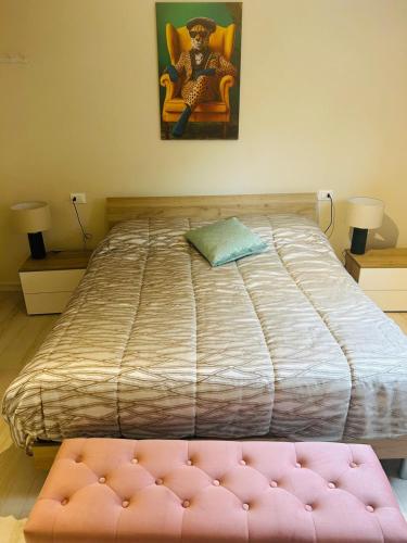 a bedroom with a large bed with a pink ottoman at Parrot House in Bertinoro