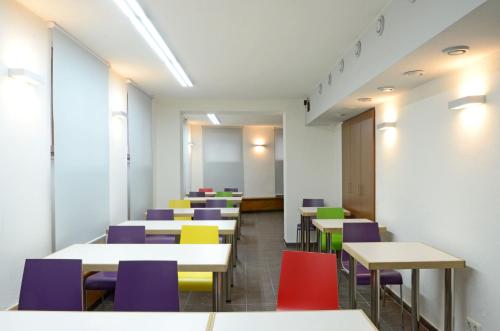a classroom with tables and colorful chairs at Hotel & Apartments Fürstenhof am Bauhaus in Weimar