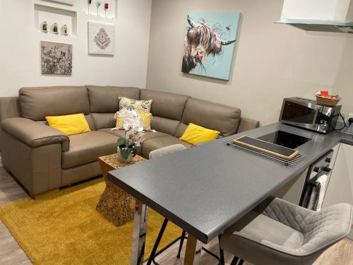 a living room with a couch and a table at Chalet on the Green - Self Contained with parking. in Inshes