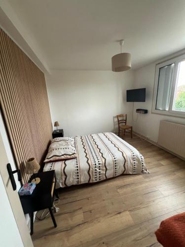 a bedroom with a bed and a desk and a window at Charming T2- apartment in Beauvais in Beauvais