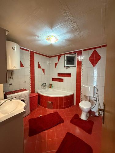 a bathroom with a tub and a toilet and a sink at Apartment AMRA in Tuzla