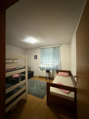 a bedroom with two bunk beds and a window at Apartment AMRA in Tuzla