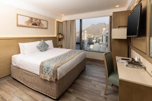 a hotel room with a bed and a large window at Violet Al Azizia Hotel MASJID Al Qatari in Mecca