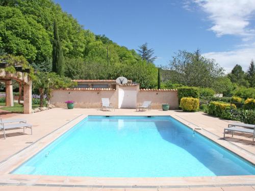 a swimming pool in a yard with two chairs at Luxurious holiday home with private pool in Salernes