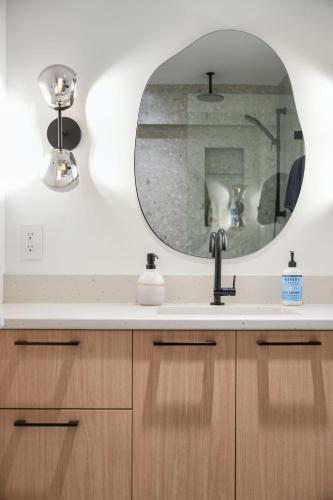 a bathroom with a sink and a mirror at Private Cedar Sauna Retreat - Kitchenette, King Bed, Spa Bath - Deep Cove in North Vancouver