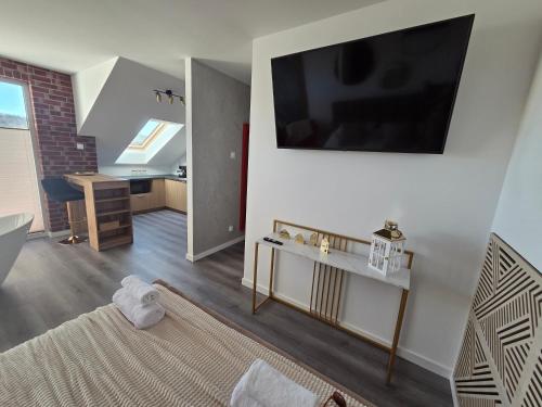 a living room with a bed and a television on a wall at Golden Heaven z wanną in Lębork