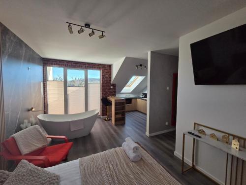 a bathroom with a tub and a bedroom with a bed at Golden Heaven z wanną in Lębork