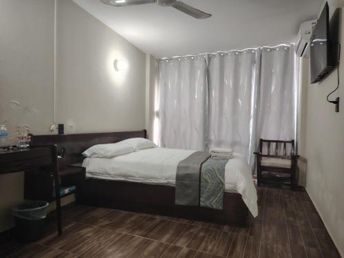 a small bedroom with a bed and a window at Hotel la fortuna in Tuxpan de Rodríguez Cano