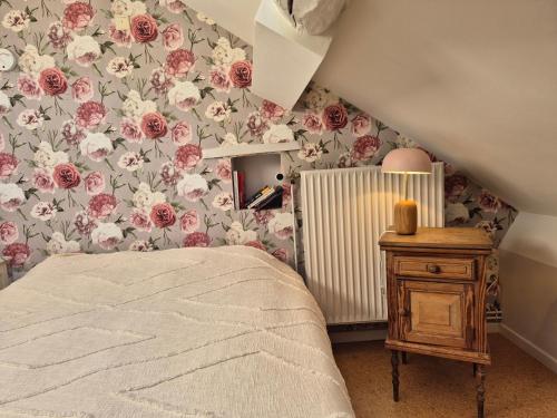 a bedroom with pink and white flowers on the wall at Chambre de Amandine à Gerpinnes in Gerpinnes